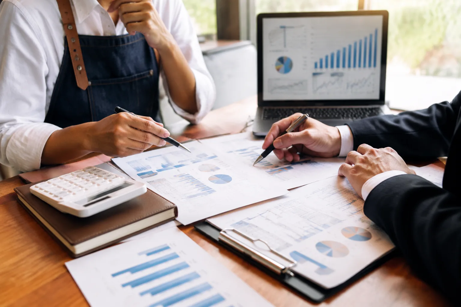Small business owner reviewing tax documents and profit and loss statements with a mortgage advisor